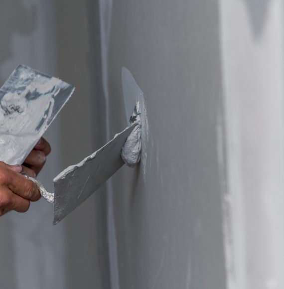 old manual worker with wall plastering tools renovating house old manual worker with wall plastering tools renovating house. Plasterer renovating indoor walls and ceilings with float and plaster.